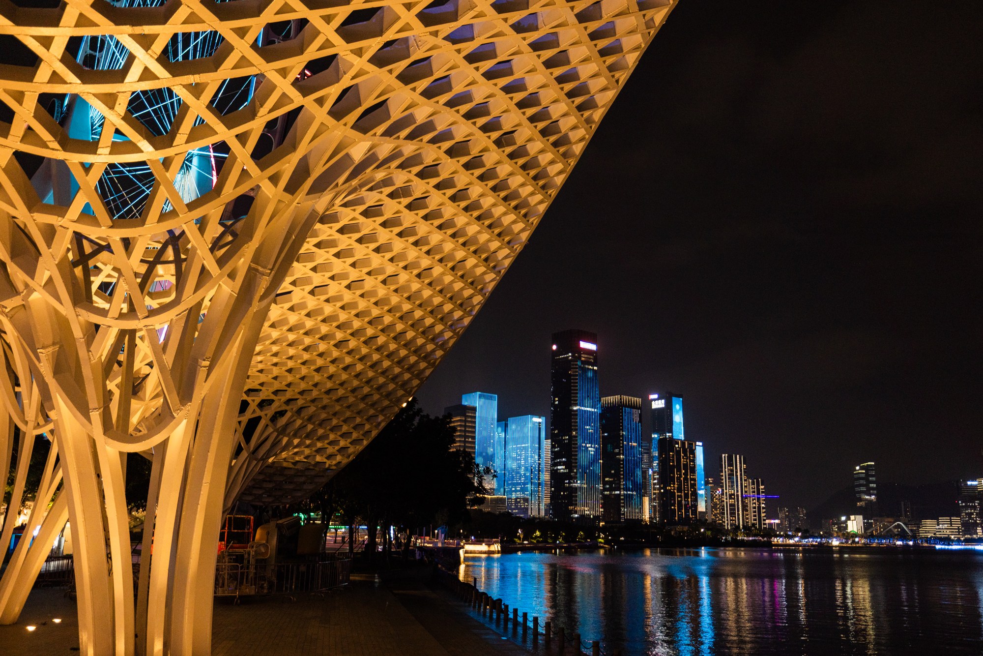 Gouden lattice-luifel kadert een nachtelijke skyline met waterreflectie, China