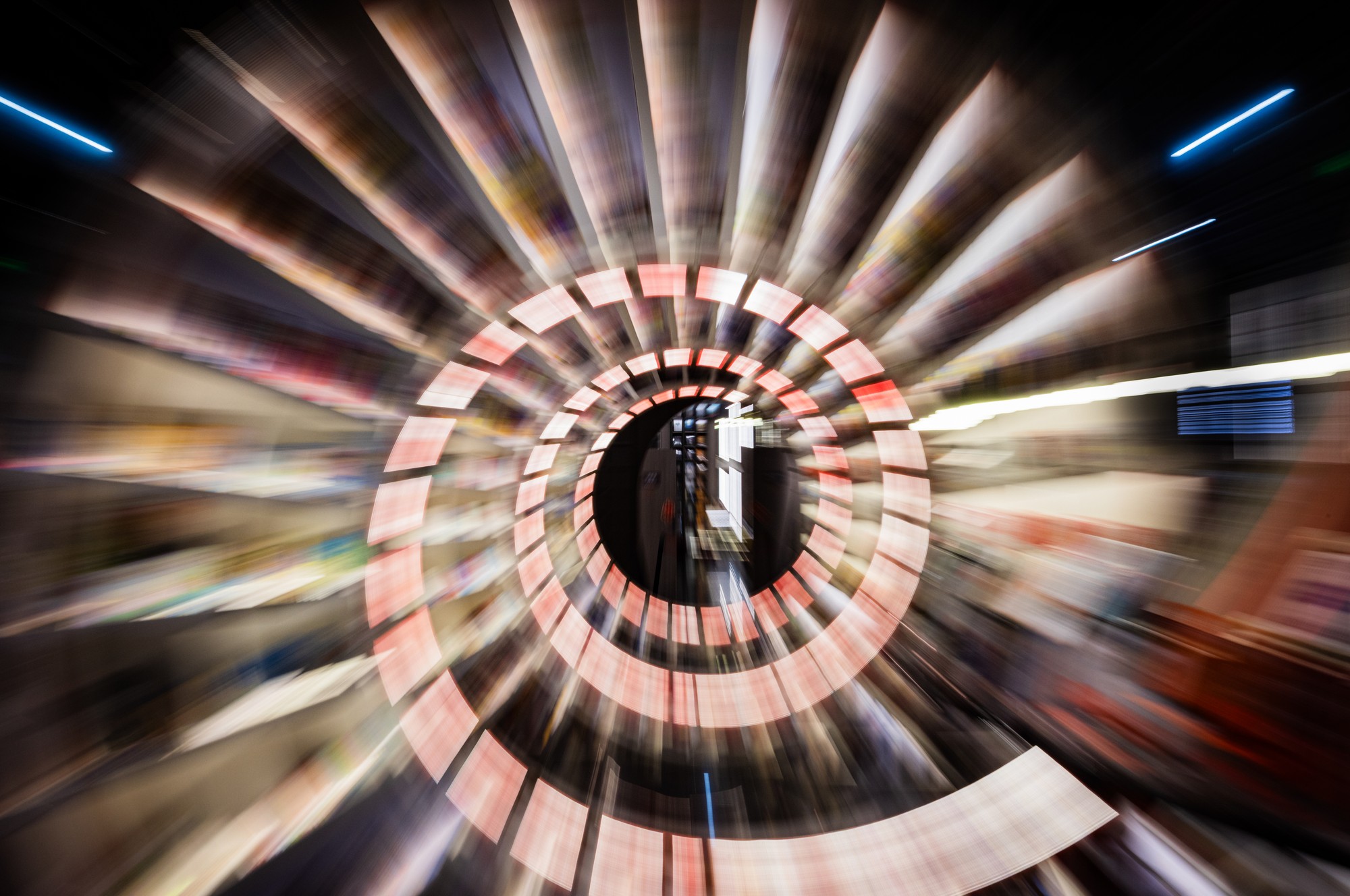 Zoom-burst van de spiraalvormige boekwinkel: rode en witte ringen exploderen radiaal vanuit een scherp centraal punt, China