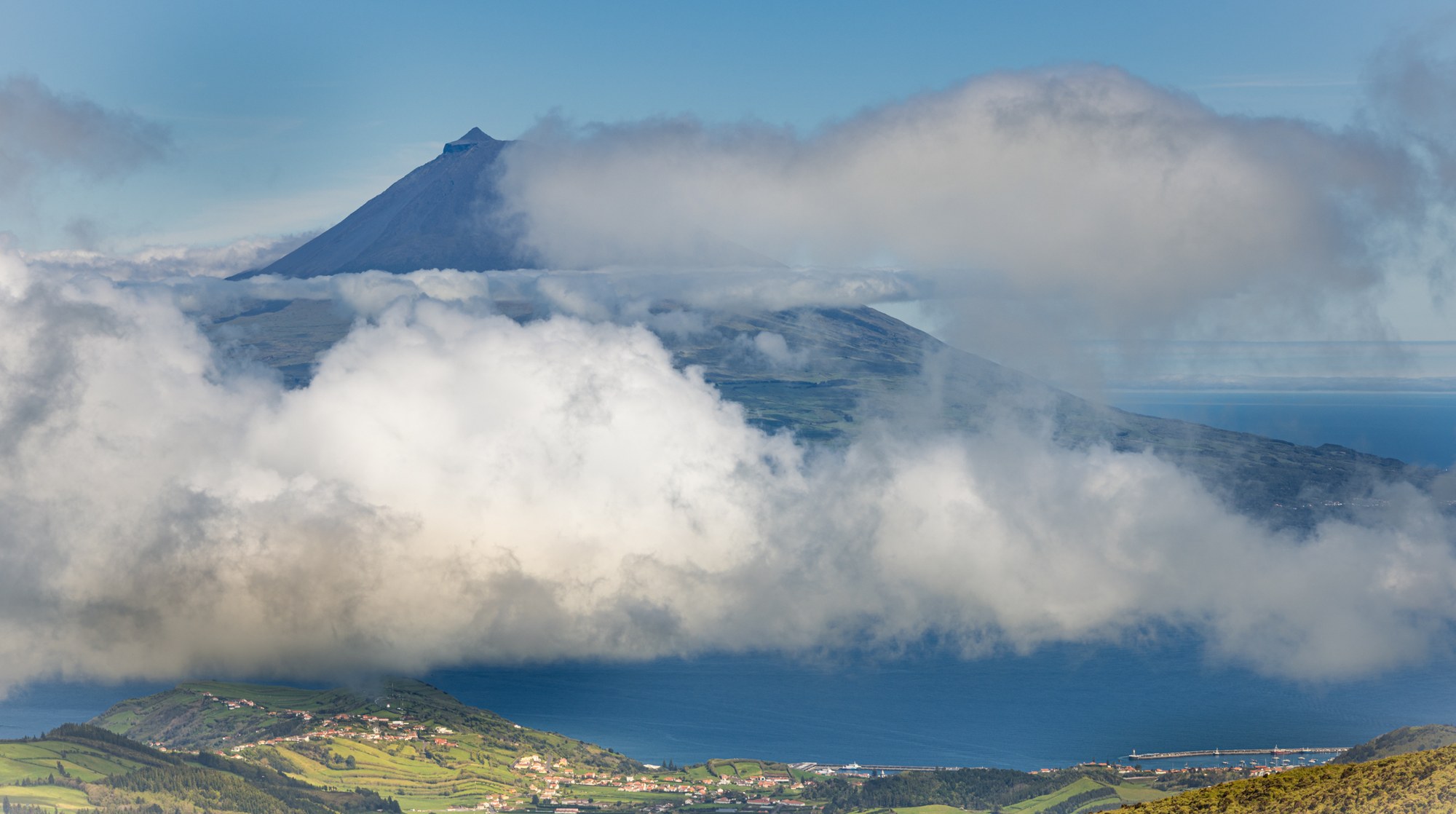 De vulkaan Pico boven een wolkendek en de kustlijn, Azoren
